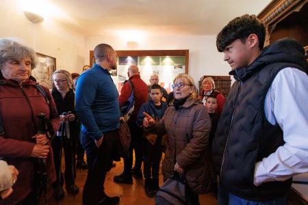 Lokalna turistična vodnica Jerica Strle predstavlja pohodnikom Kettejevo spominsko sobo